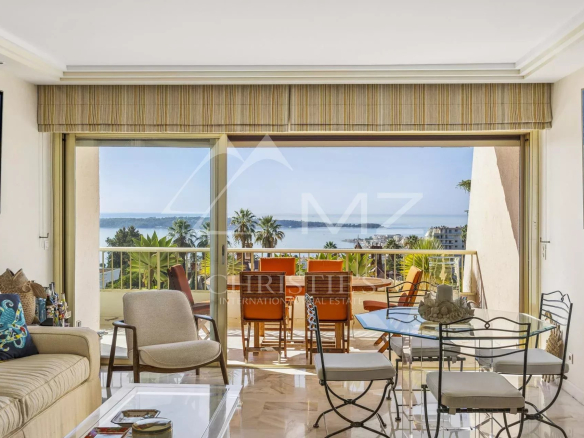 Séjour lumineux d'un appartement à Cannes avec vue sur la mer et terrasse.