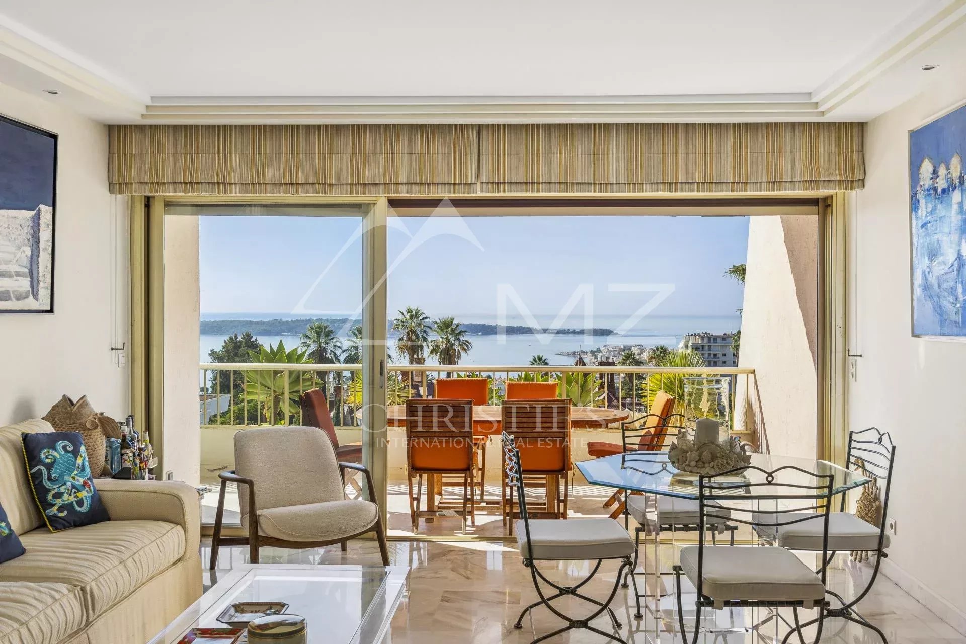 Séjour lumineux d'un appartement à Cannes avec vue sur la mer et terrasse.