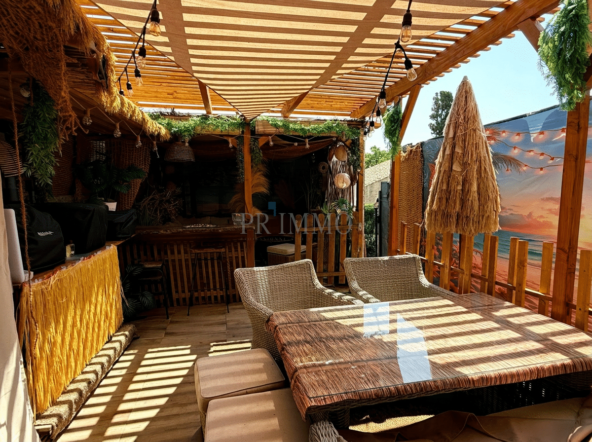 Terrace of a house with a grocery store Wooden terrace with wicker furniture, parasol and seaside decoration.