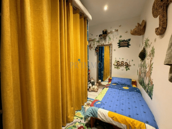 Colorful bedroom with a single bed and animal-themed wall decorations.