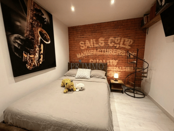 Attic room with double bed and brick wall decoration.