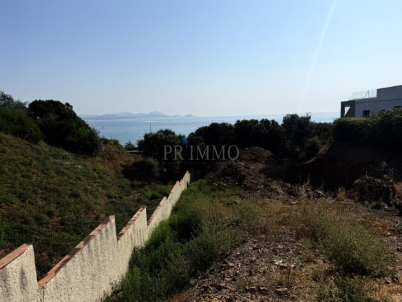 Terrain à bâtir avec vue sur la mer aux Issambres, entouré de végétation.