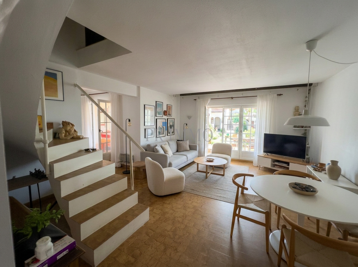 Intérieur d'une villa moderne avec salon lumineux et salle à manger.