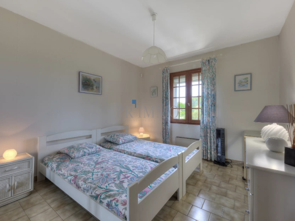 Bright room with twin beds and simple decor.
