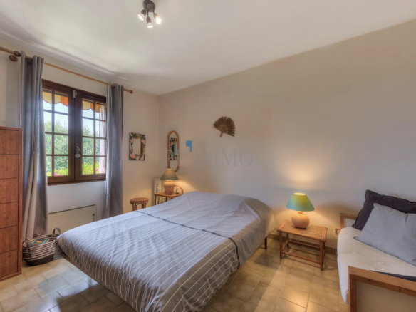 Bright room with a double bed and windows offering a view of the garden.