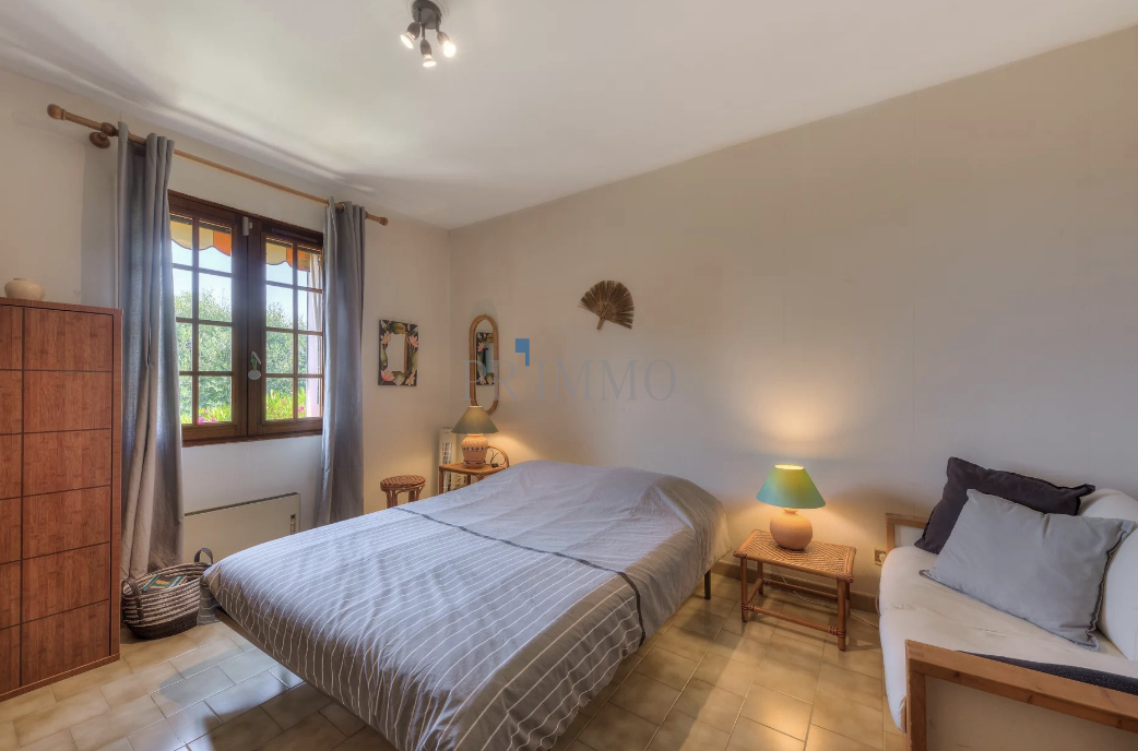 Bright room with a double bed and windows offering a view of the garden.