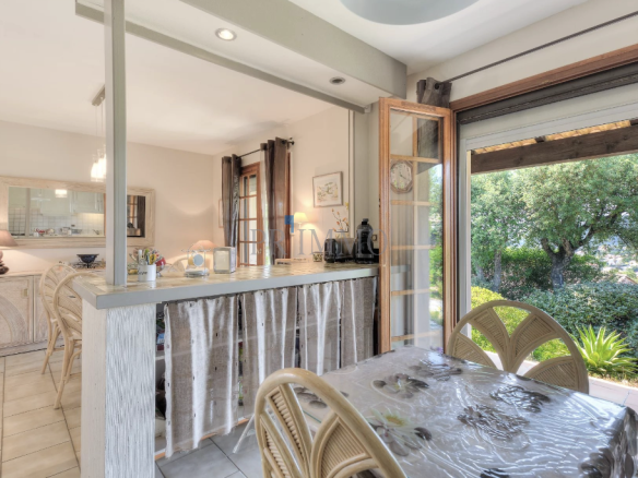 Interior of a single-storey villa with open kitchen and garden view.