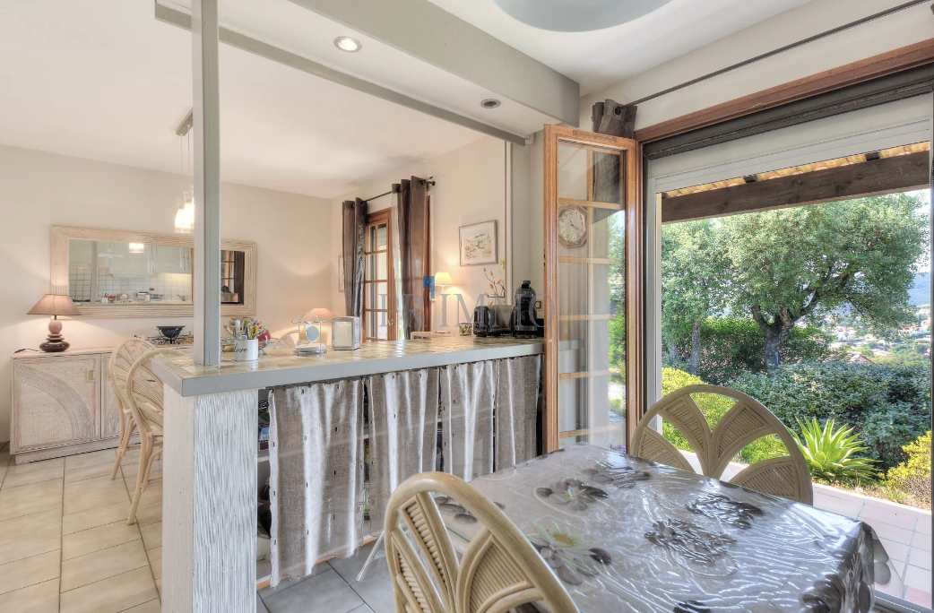Interior of a single-storey villa with open kitchen and garden view.