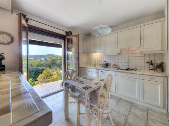 Bright kitchen with views of the garden and the sea, located in a villa in Saint Aygulf.