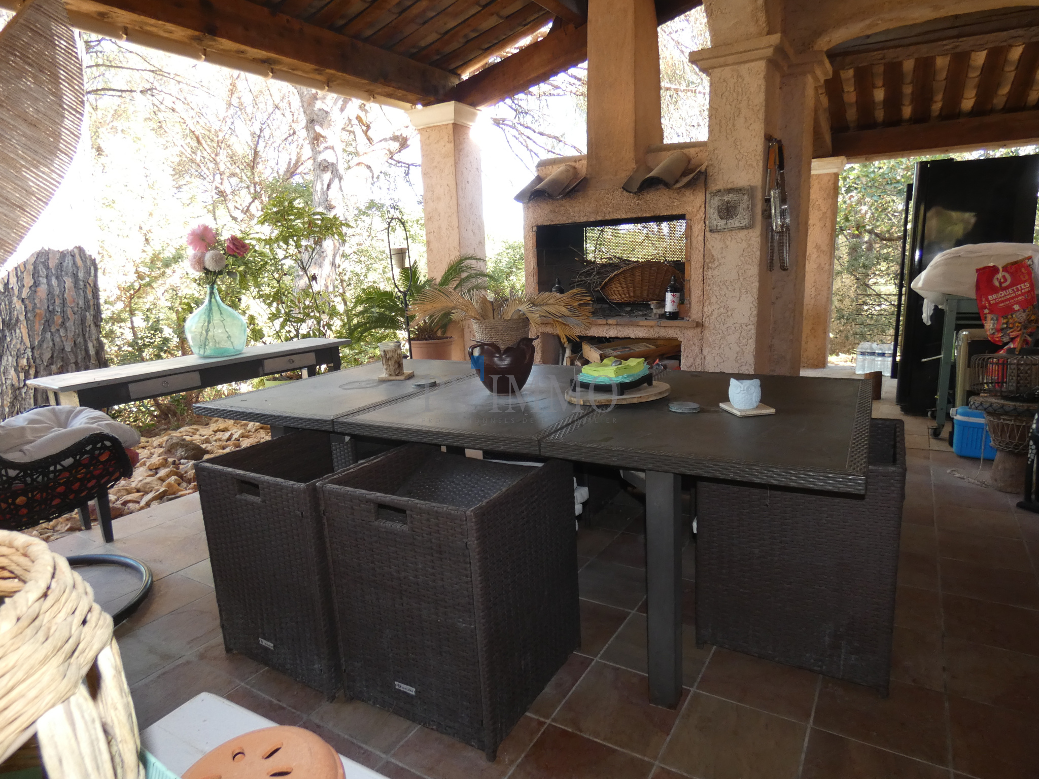 Terrasse d'une villa avec table en extérieur et barbecue, entourée de nature à Vidauban.