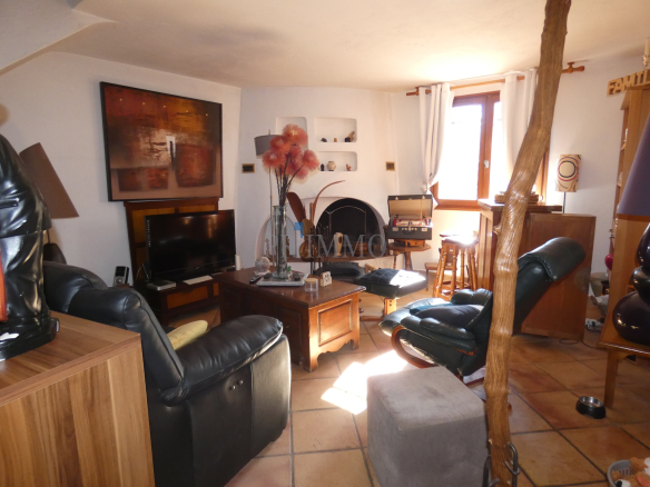Salon d'une villa avec cheminée, meubles confortables et décoration chaleureuse.