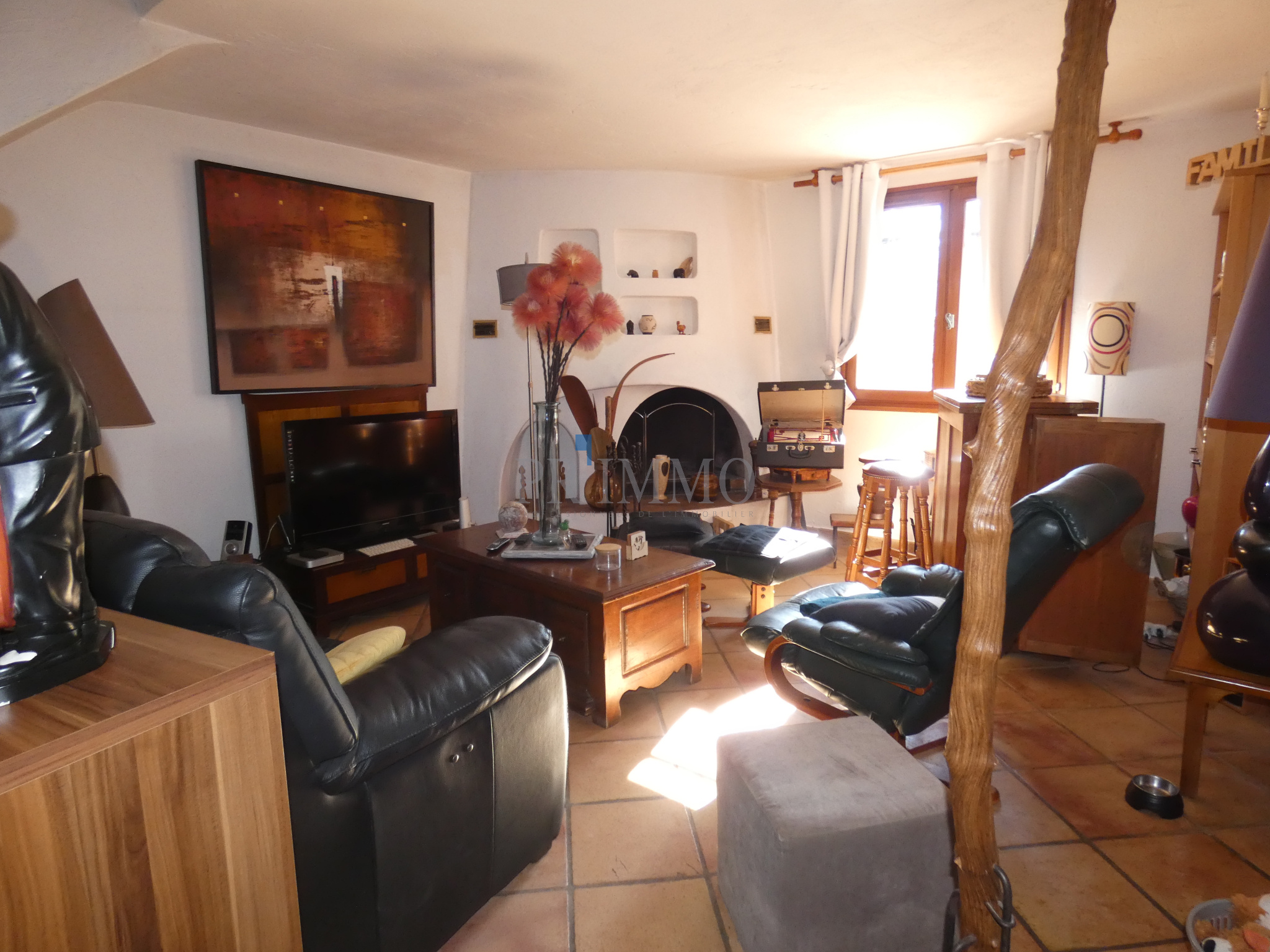 Salon d'une villa avec cheminée, meubles confortables et décoration chaleureuse.