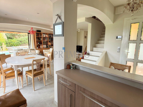 Intérieur d'une villa rénovée avec séjour lumineux, salle à manger et cuisine ouverte.