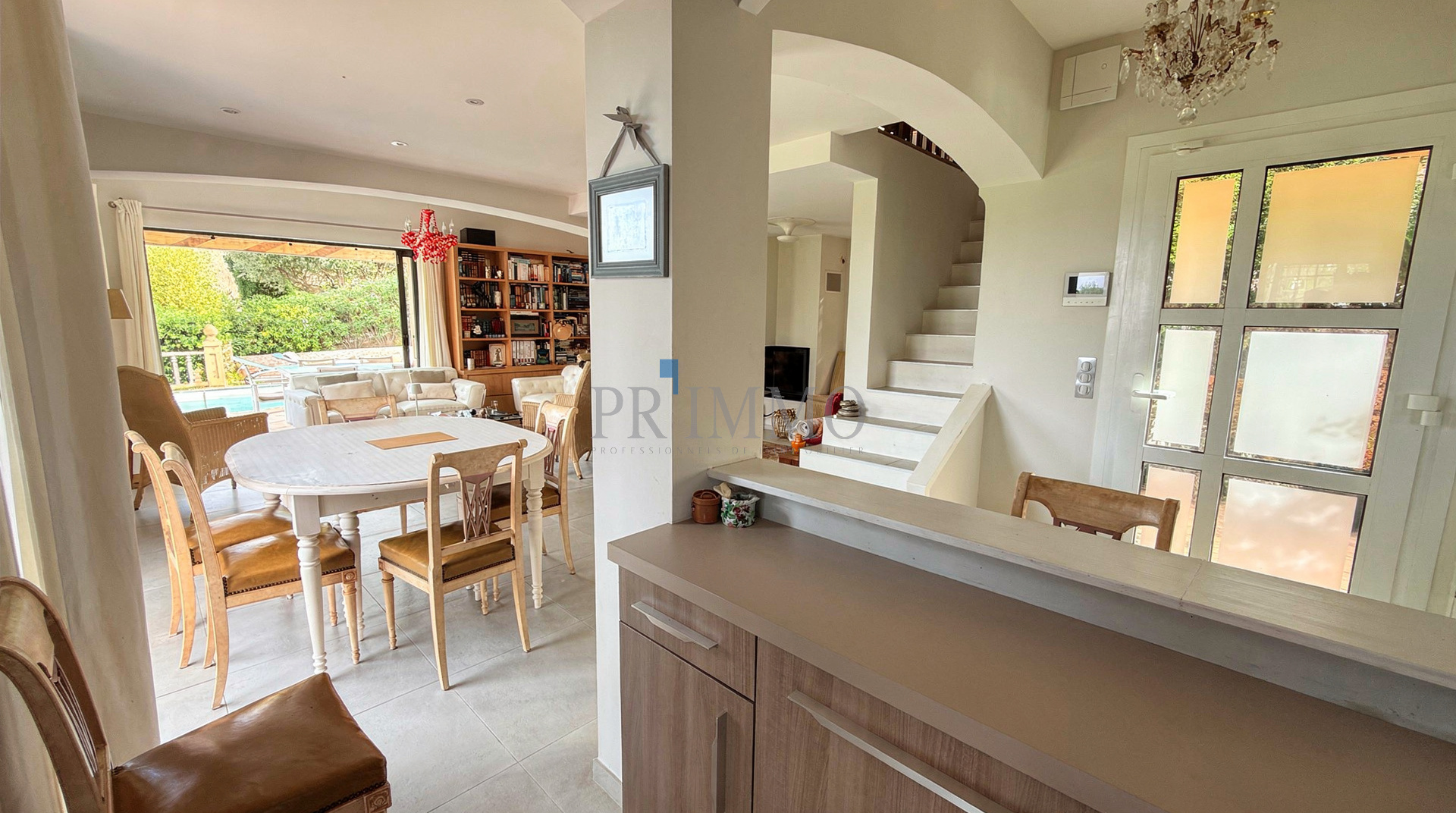 Intérieur d'une villa rénovée avec séjour lumineux, salle à manger et cuisine ouverte.