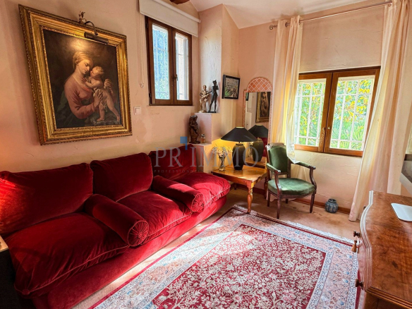 Intérieur d'une villa rénovée avec un salon confortable et une peinture au mur.