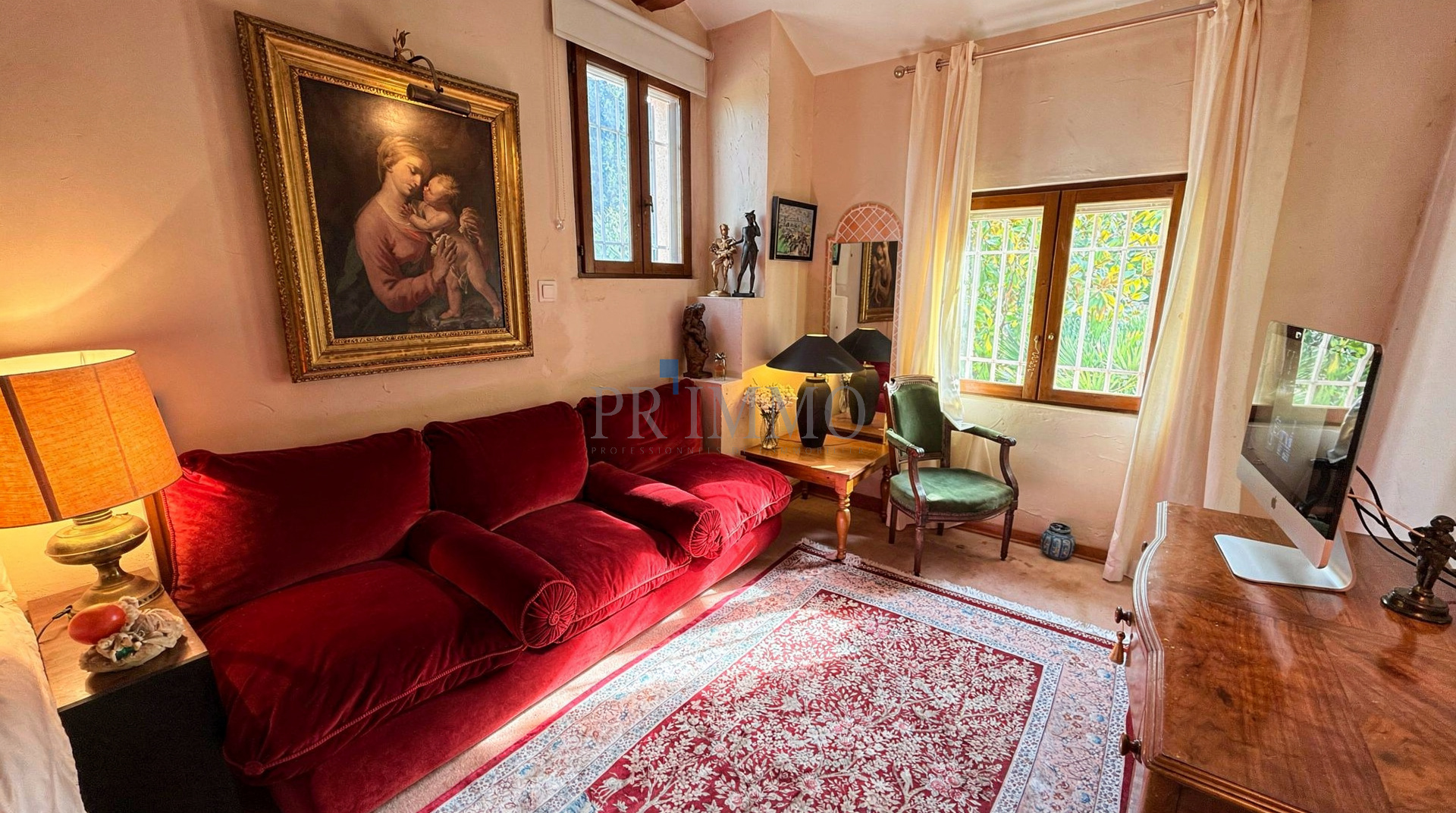 Intérieur d'une villa rénovée avec un salon confortable et une peinture au mur.