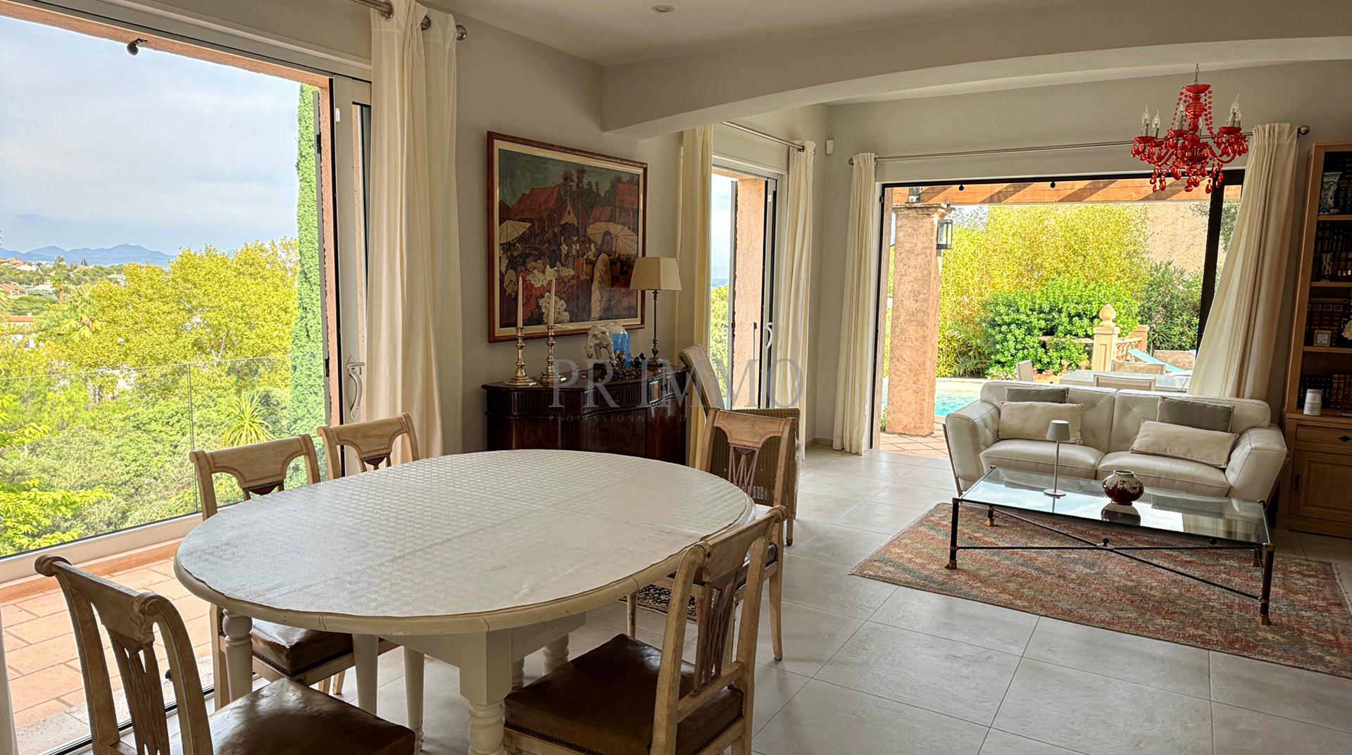 Intérieur d'une villa rénovée à Les Issambres avec vue sur la mer, salle à manger et salon lumineux.