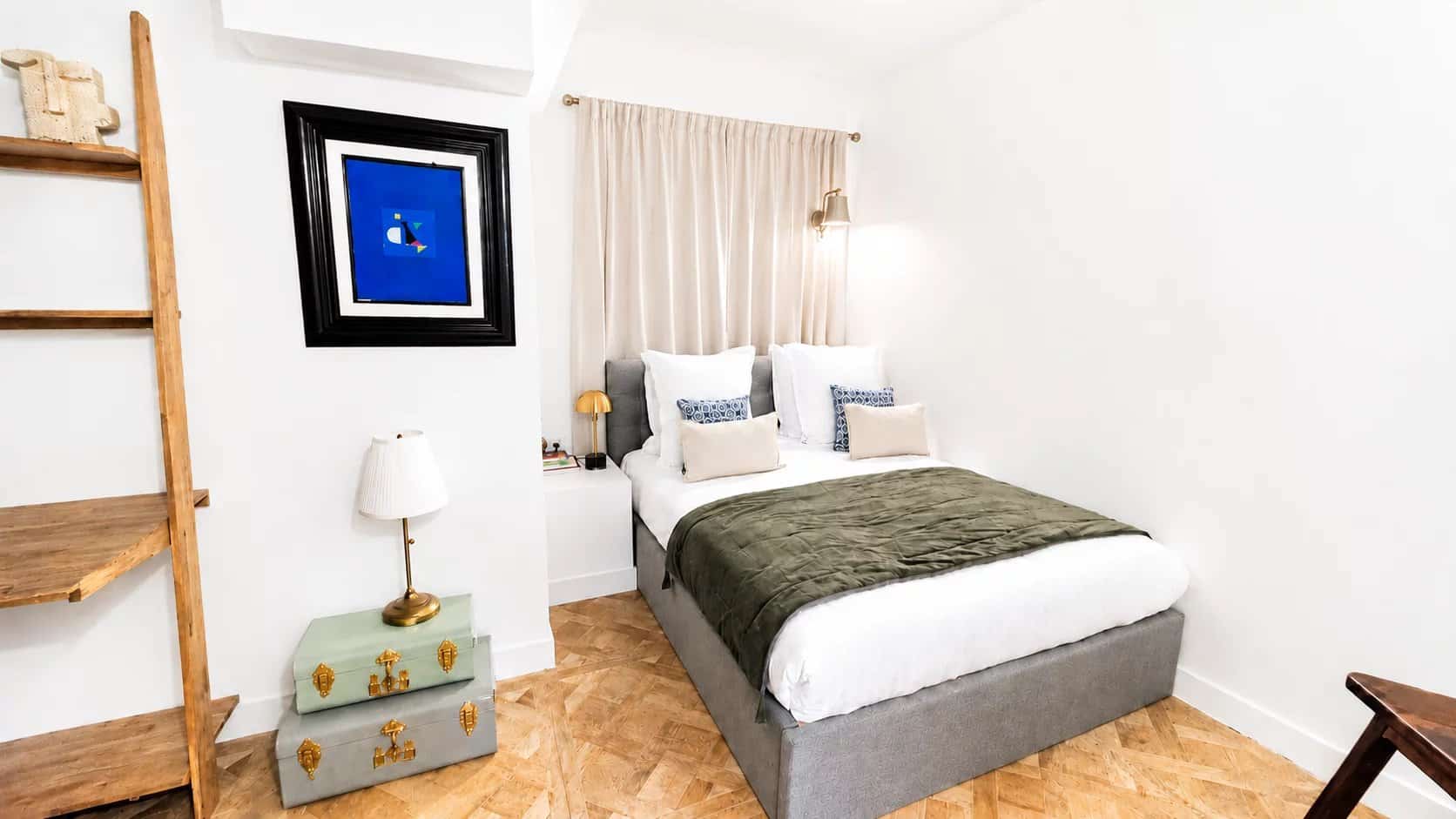 Chambre d'un appartement rénové à Paris 18ème avec lit double et décoration moderne.
