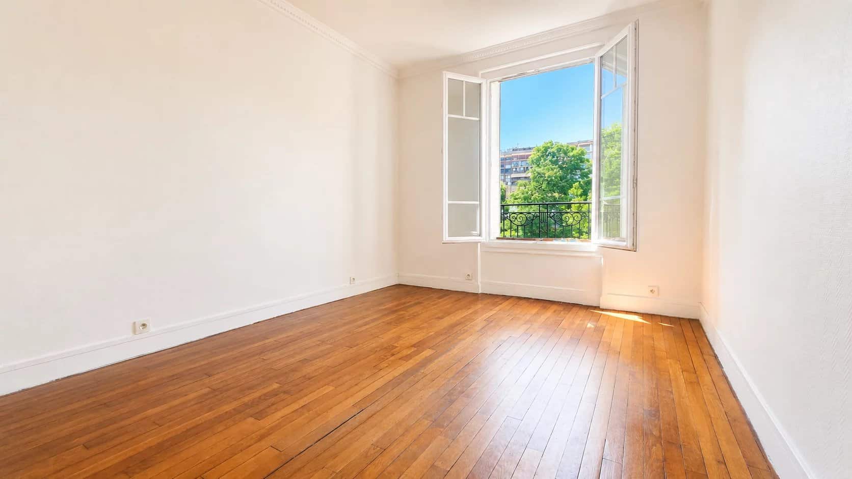 Interior of a renovated apartment in Meudon with parquet flooring and windows opening to the outside.