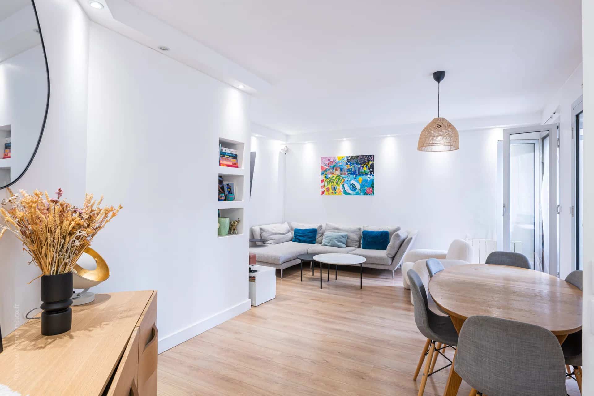 Intérieur d'un appartement moderne à Neuilly-sur-Seine avec salon et salle à manger.