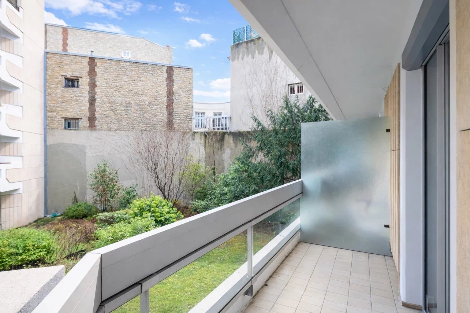 Balcon d'un appartement avec vue sur un jardin intérieur à Neuilly-sur-Seine.
