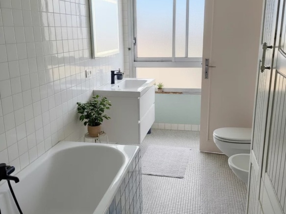 Salle de bain moderne avec baignoire et fenêtre, duplex à Courbevoie.