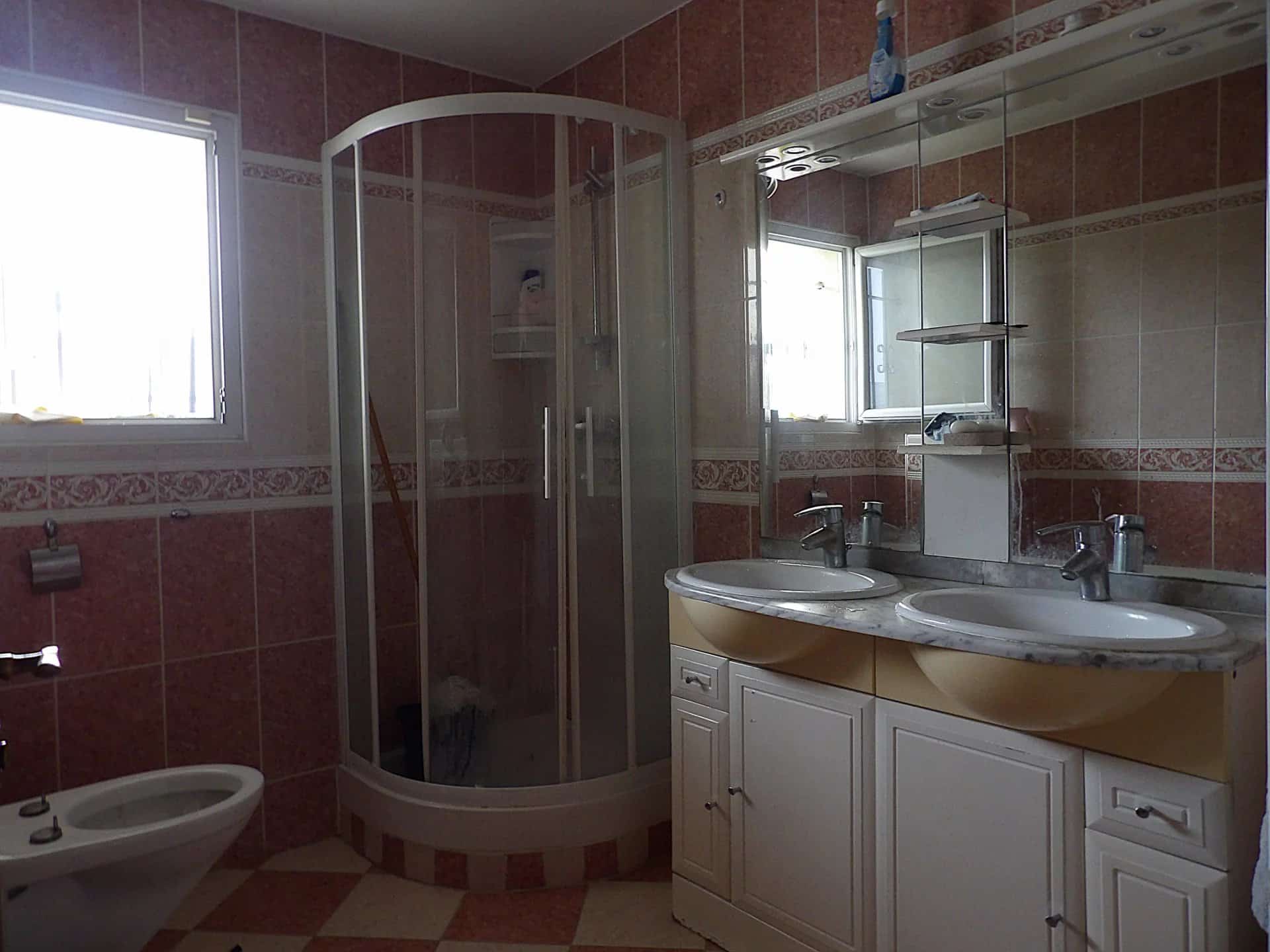 Salle de bain d’une maison à Bobigny Salle de bain avec douche et double vasque dans une maison individuelle.