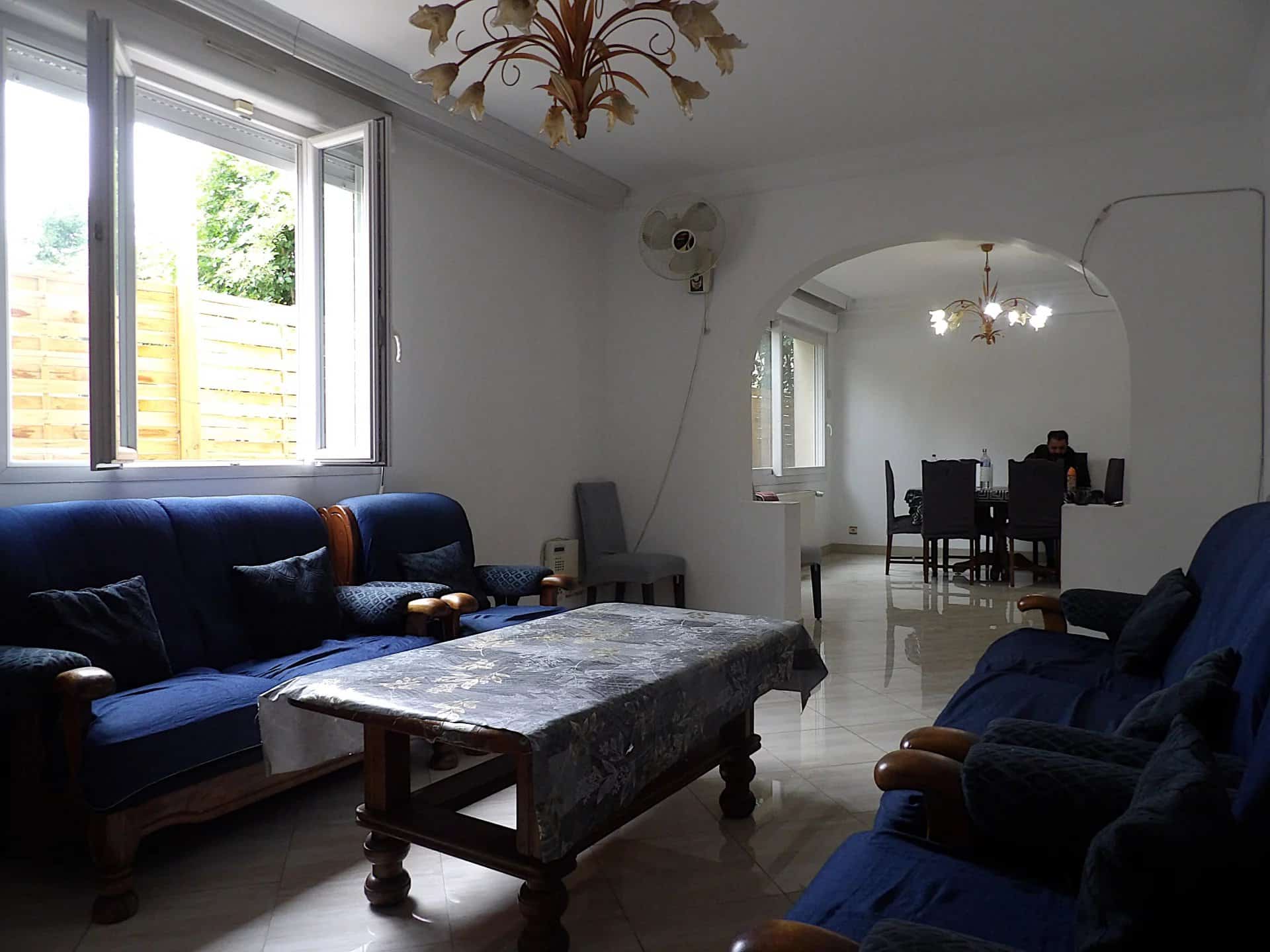 Intérieur d’une maison à Bobigny Intérieur d'une grande maison individuelle avec salon et salle à manger, meubles en bois et décoration simple.