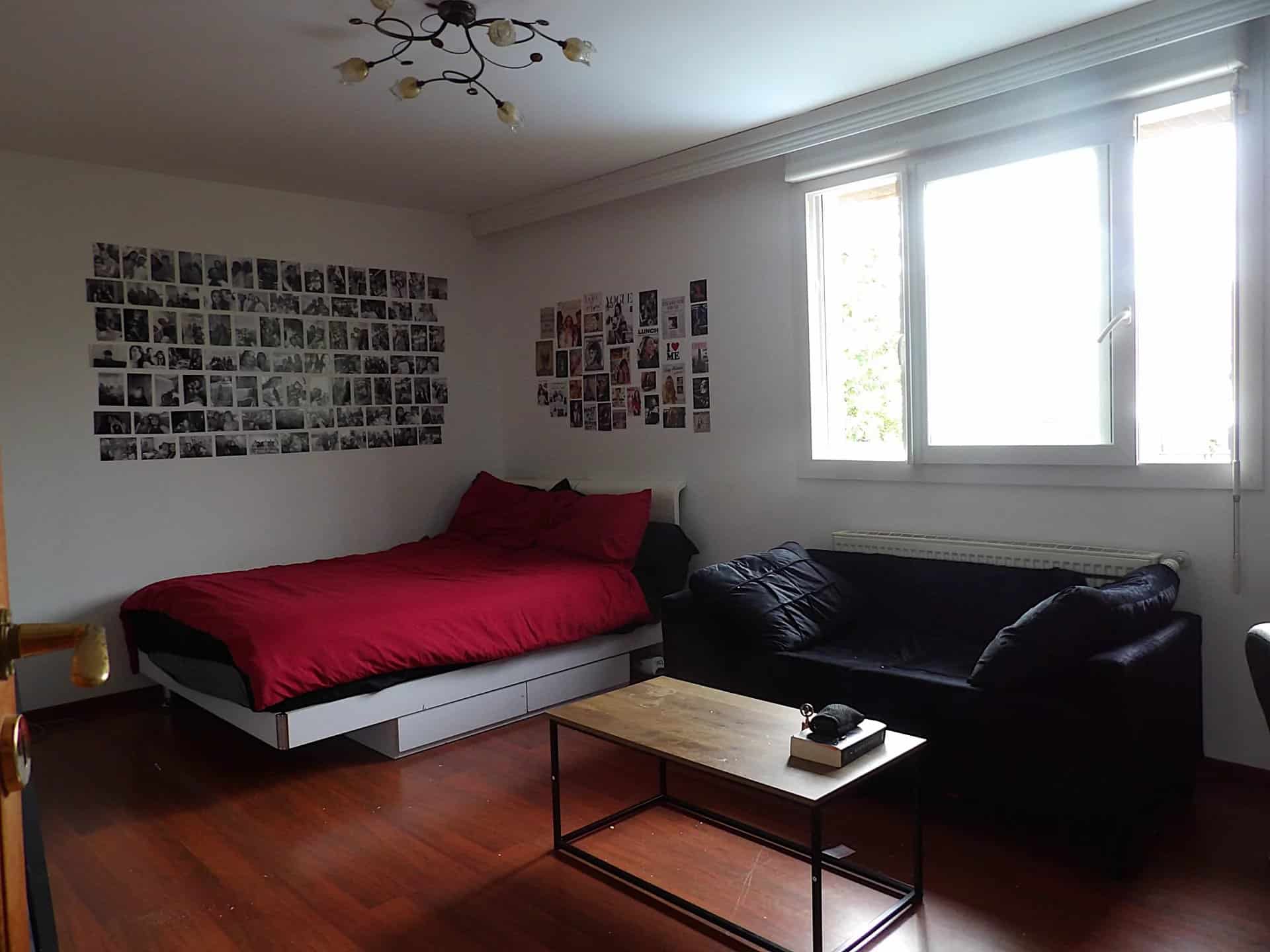 Chambre d’une maison à Bobigny Chambre avec lit simple, canapé et murs décorés de photos.
