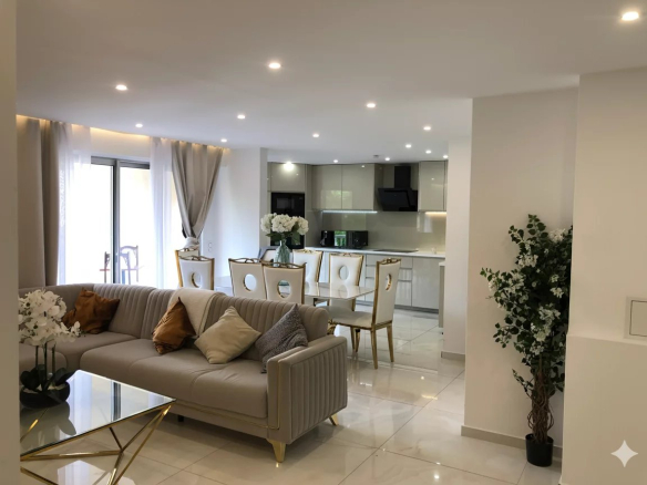 Salon lumineux d'un appartement rénové avec cuisine ouverte et terrasse à Courbevoie.