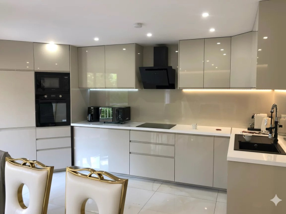 Cuisine moderne et lumineuse d'un appartement rénové à Courbevoie, avec meubles en finition brillante.