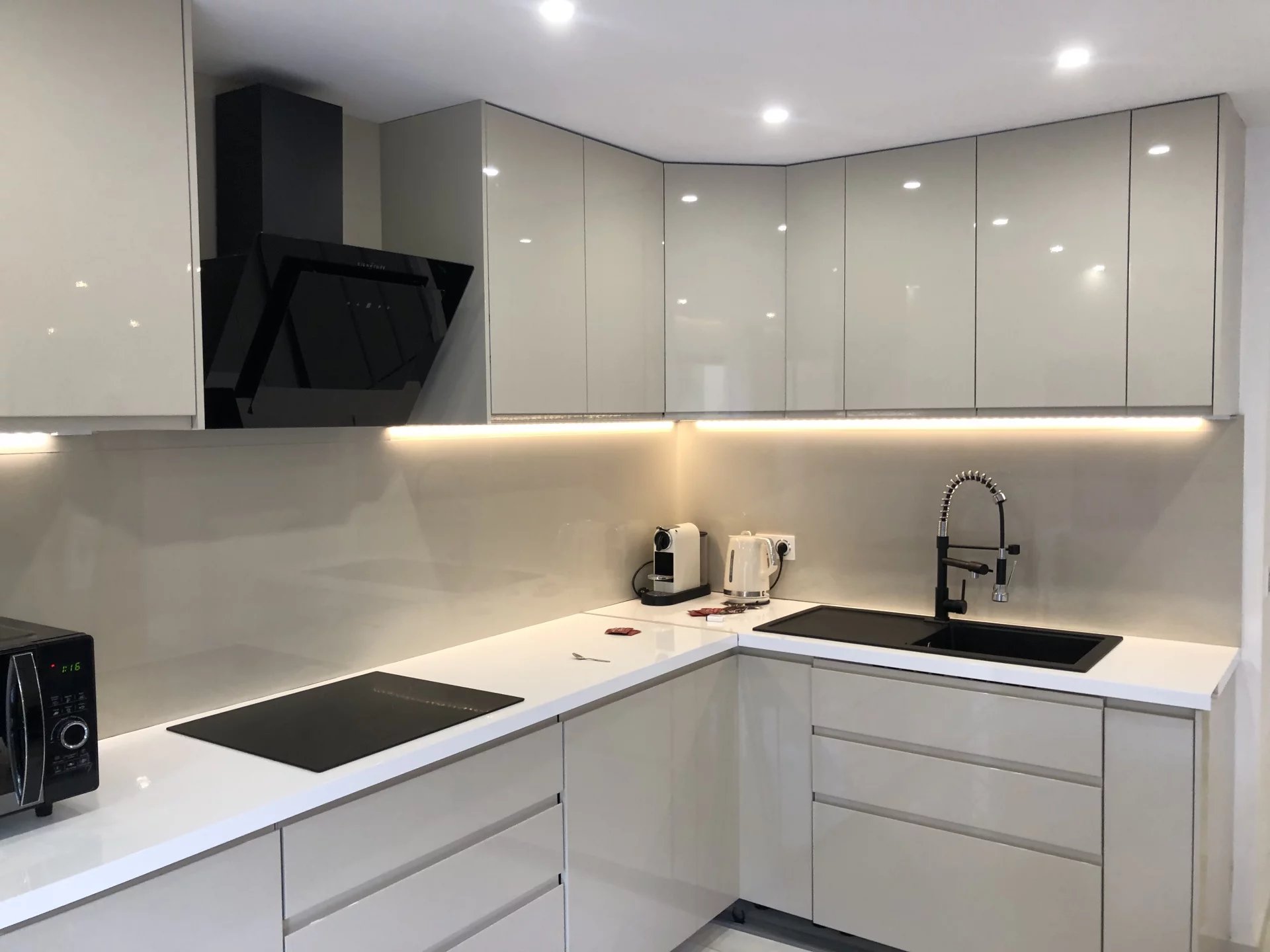 Cuisine rénovée d’un appartement à Courbevoie Cuisine moderne et lumineuse avec meubles en bois clair et plan de travail blanc.