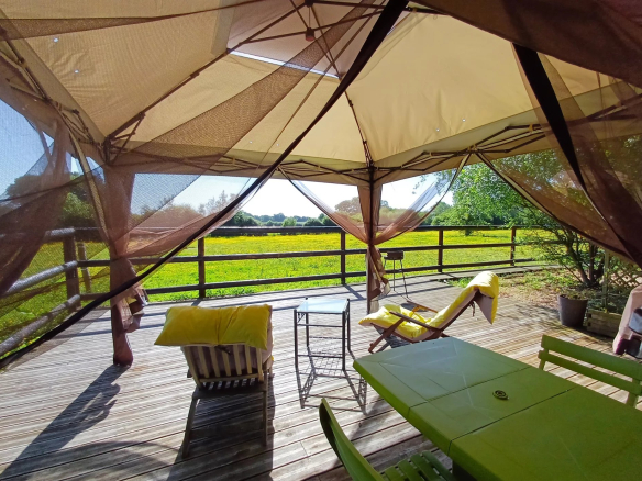 Terrasse d'un ensemble immobilier avec vue sur un parc verdoyant dans le Parc Naturel Régional du Perche.