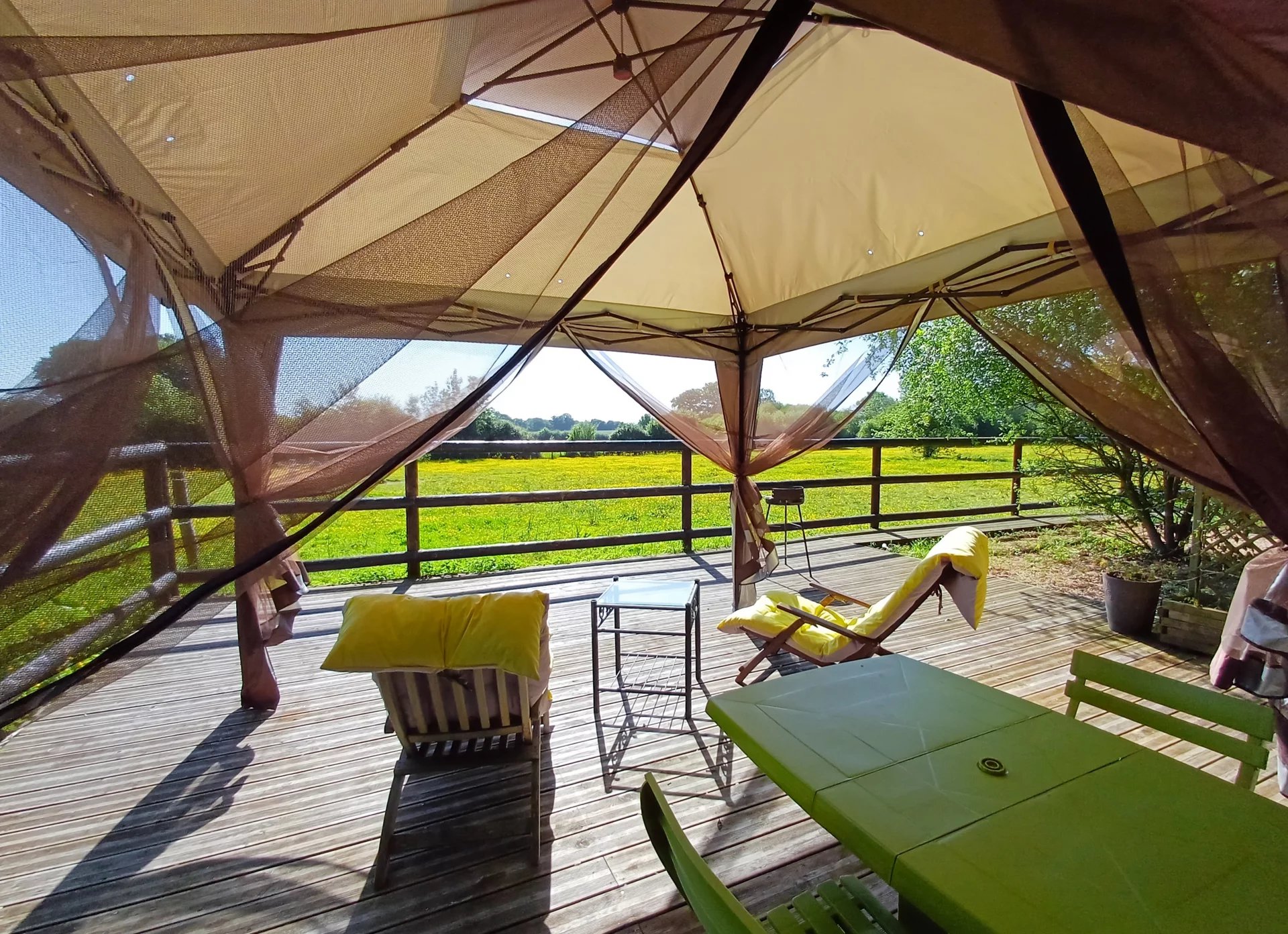 Terrasse d'un ensemble immobilier avec vue sur un parc verdoyant dans le Parc Naturel Régional du Perche.