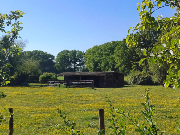 Ensemble immobilier dans un champ avec un bâtiment en bois, Parc Naturel Régional du Perche.