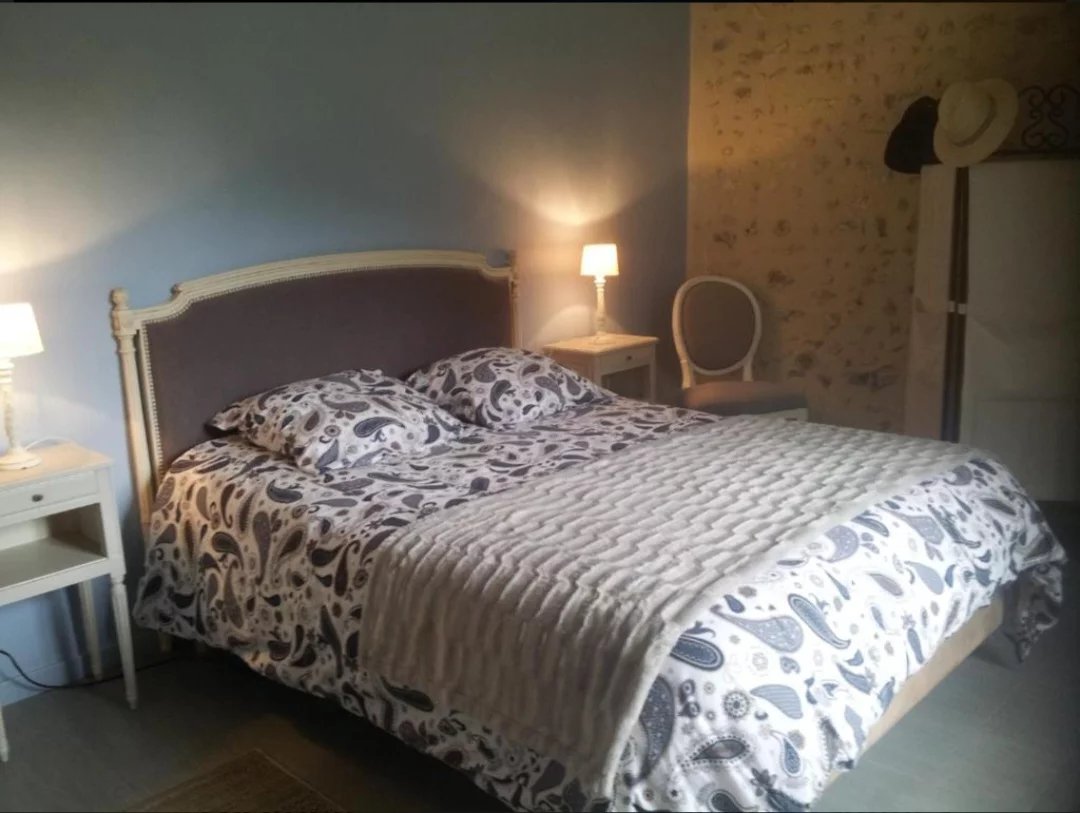 Chambre avec lit double et décoration sobre, éclairage doux.