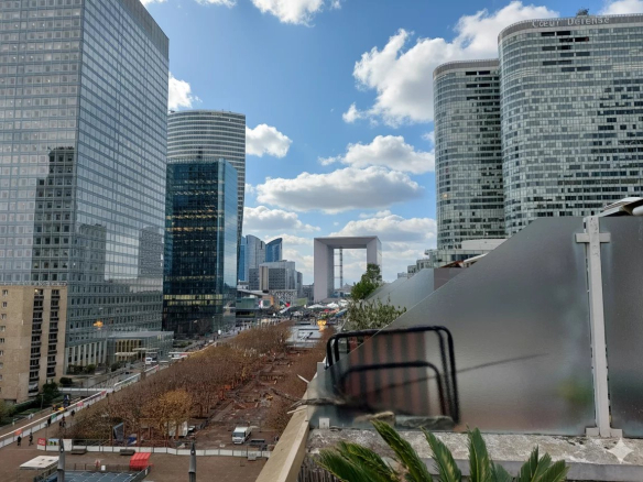 Vue dégagée depuis un duplex au 5ème étage à Courbevoie, montrant l'Arc de Triomphe et la Grande Arche de La Défense.