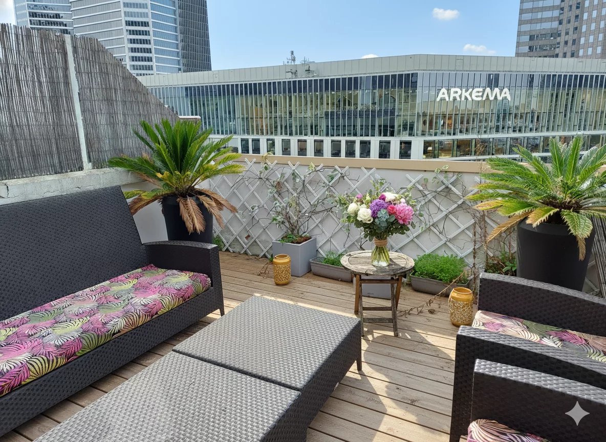 Terrace of a duplex in Courbevoie Terrace of a duplex with rattan furniture and plants, overlooking modern buildings in Courbevoie.