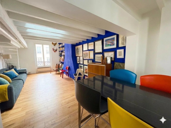 Intérieur d'un duplex lumineux avec salon et salle à manger, murs colorés et mobilier moderne.