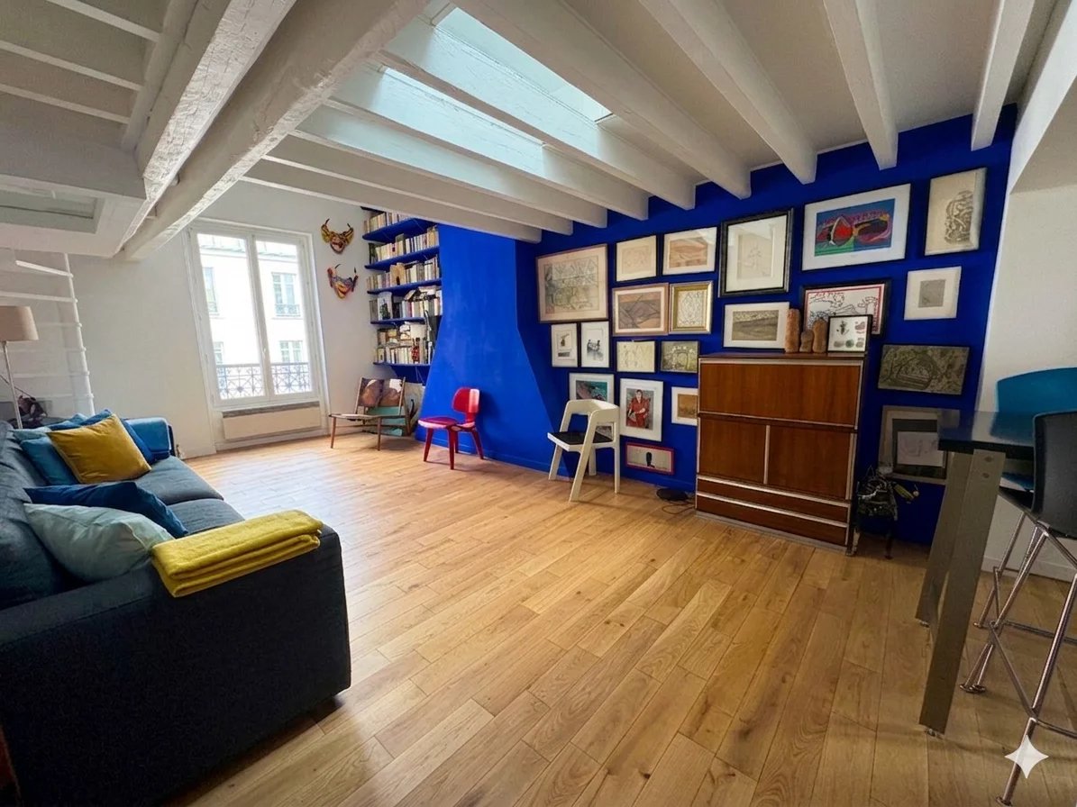 Duplex lumineux à Paris 6ème Intérieur d'un duplex lumineux avec des murs bleus et des œuvres d'art, Paris 6ème.