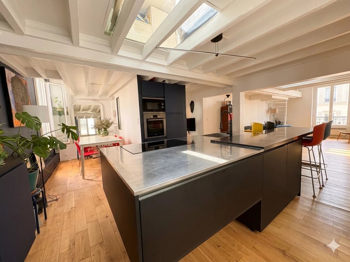 Duplex d’exception à Paris VI Intérieur d'un duplex moderne avec cuisine ouverte et lumière naturelle à Paris.
