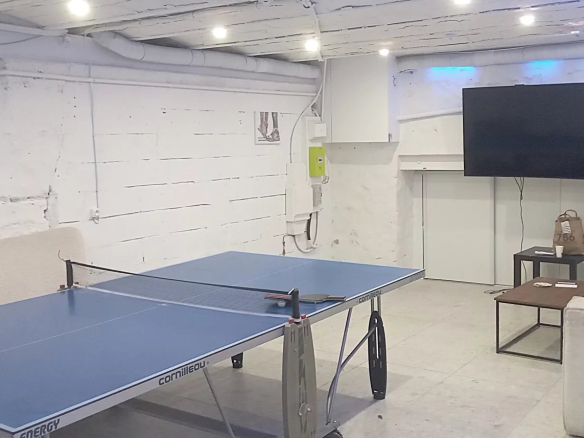 Salle de loisirs avec table de ping-pong et télévision dans un ensemble immobilier de bureaux à Choisy-le-Roi.