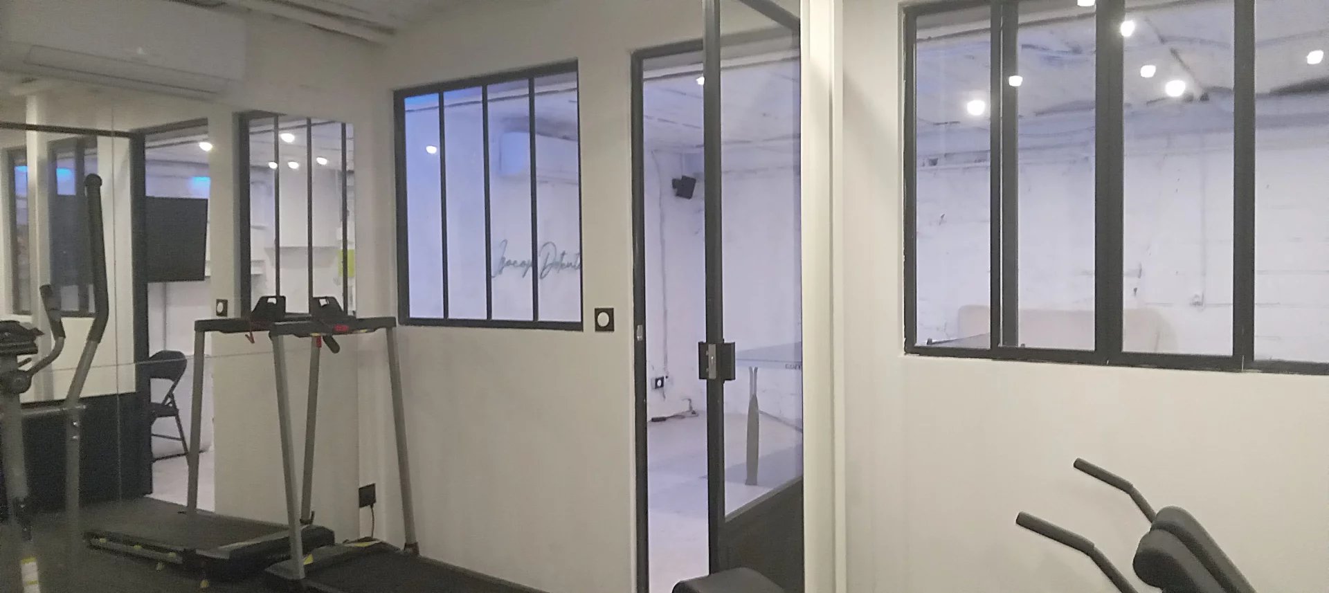 Espace de bureau à Choisy-le-Roi Intérieur d'un espace de bureau avec des fenêtres en verre et des équipements de fitness.