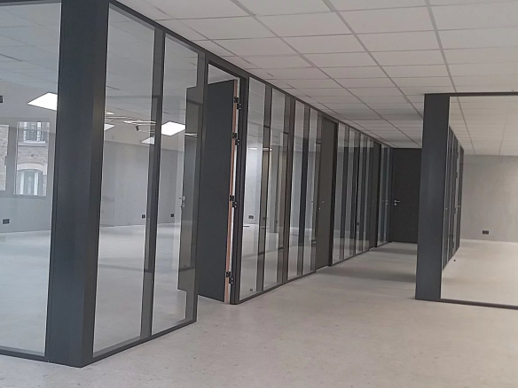 Intérieur d'un ensemble immobilier de bureaux moderne à Choisy-le-Roi, avec des cloisons vitrées.