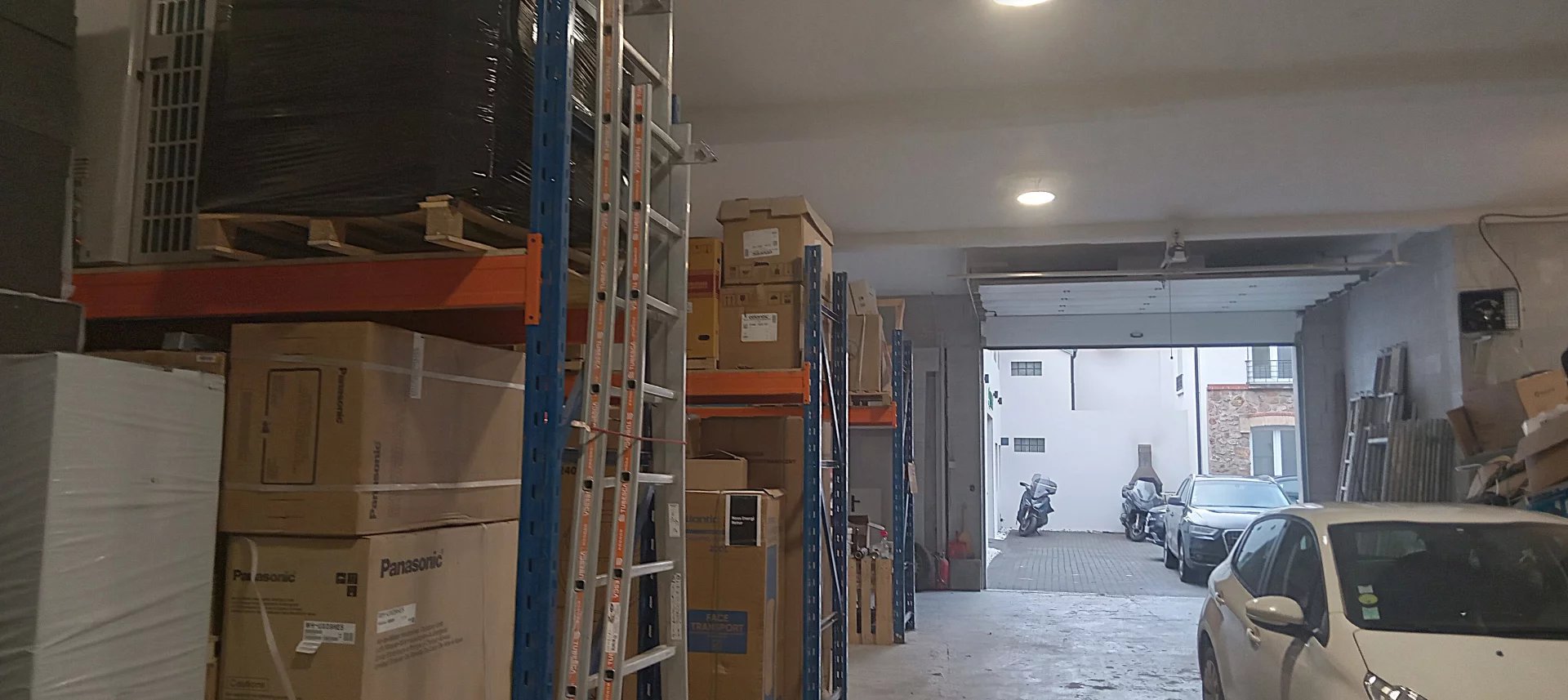 Entrepôt à Choisy-le-Roi Intérieur d'un entrepôt avec des étagères chargées de cartons et un accès à l'extérieur à Choisy-le-Roi.