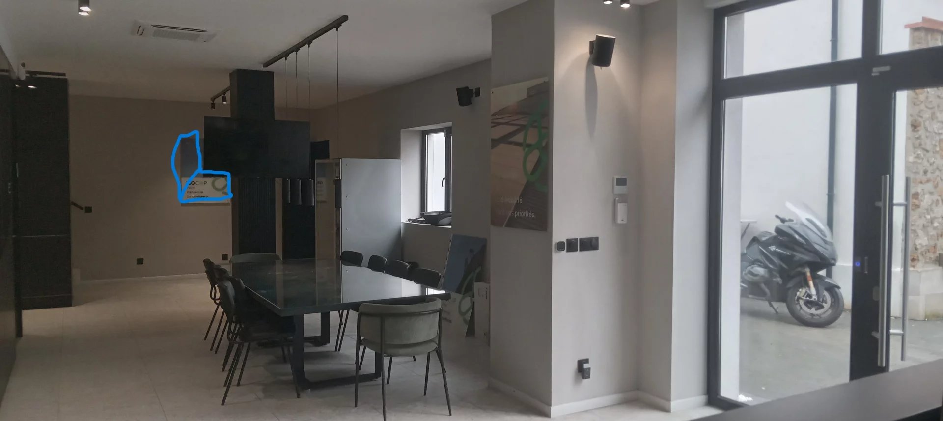 Espace de bureaux moderne à Choisy-le-Roi Intérieur d'un espace de bureaux moderne avec table et chaises, fenêtre et moto visible à l'extérieur.