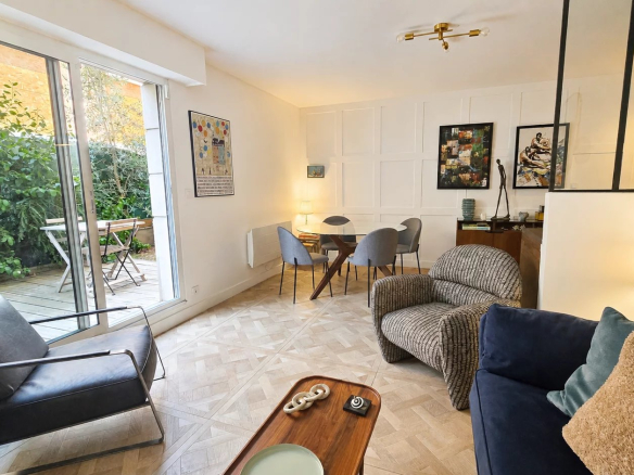 Intérieur d'un appartement rénové avec jardin privatif à Paris 18ème, salon et salle à manger.