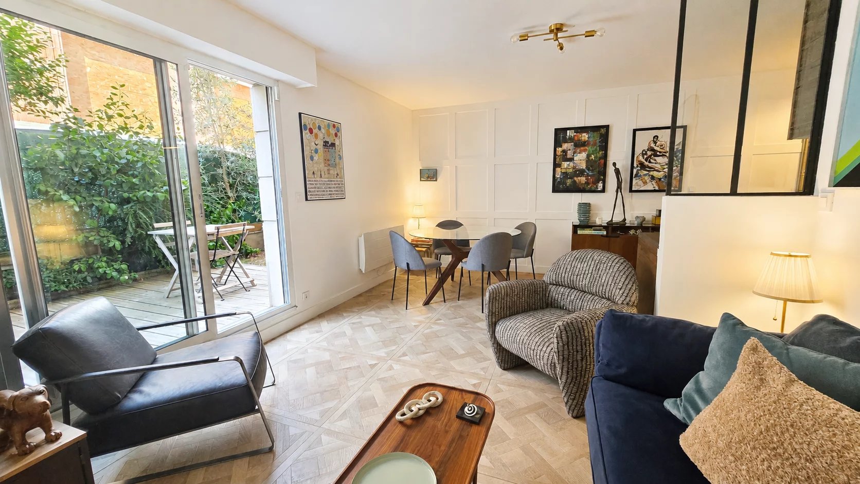 Intérieur d'un appartement rénové avec jardin privatif à Paris 18ème, salon et salle à manger.