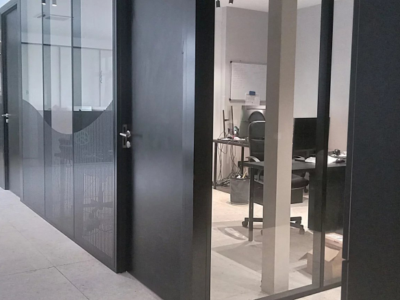 Interior of an office building complex with glass partitions and workspaces.