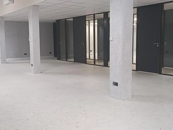 Interior of an office building complex with several workspaces and visible columns.